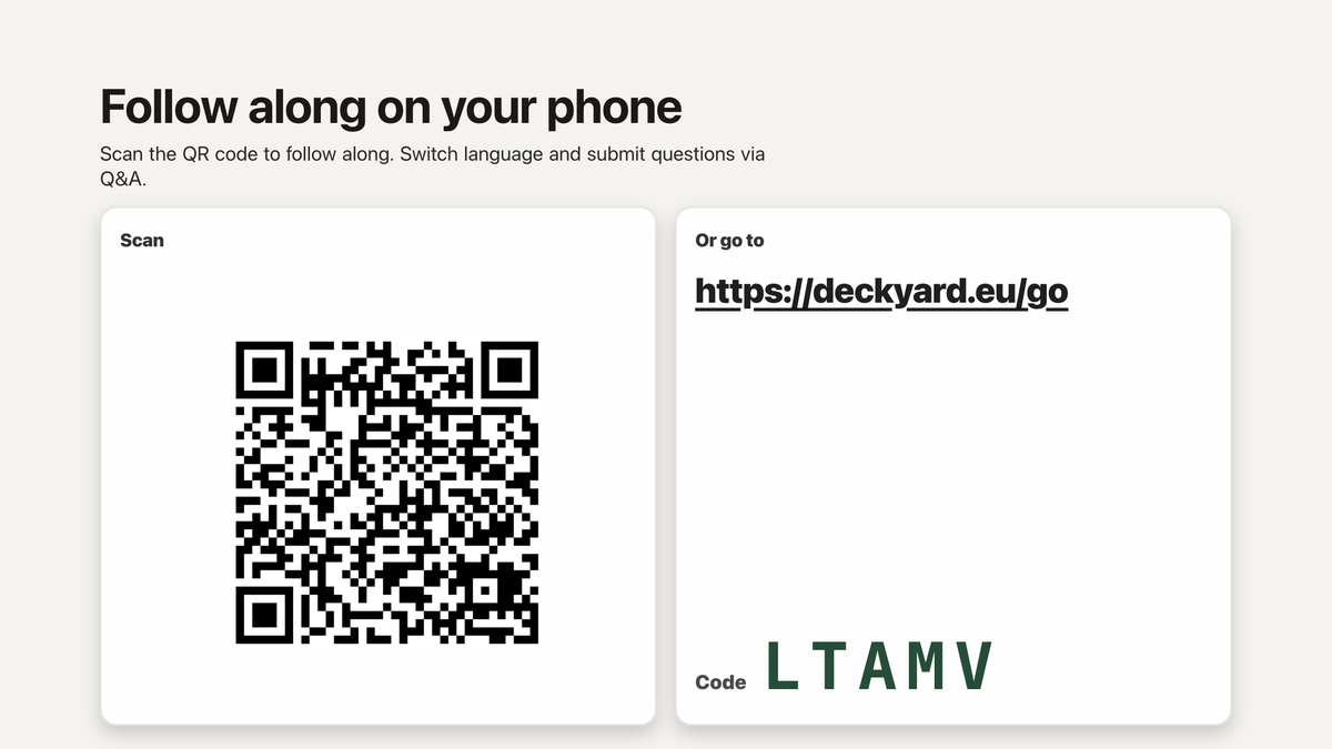 The invitation slide on the big screen: a QR code beside the address deckyard.eu/go and a five-letter access code.
